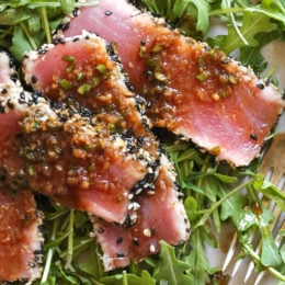 Sesame Crusted Tuna Steak on Arugula drizzled with a balsamic soy-ginger vinaigrette – yum!