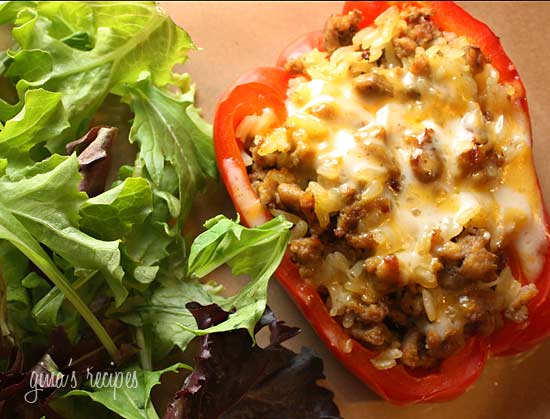 A half of a stuffed pepper with a side salad.