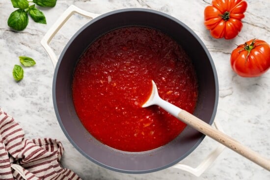This filetto di pomodoro tastes far better than store-bought pasta sauces! You only need a few ingredients for this authentic Italian recipe. Stirring filetto di pomodoro in pot.