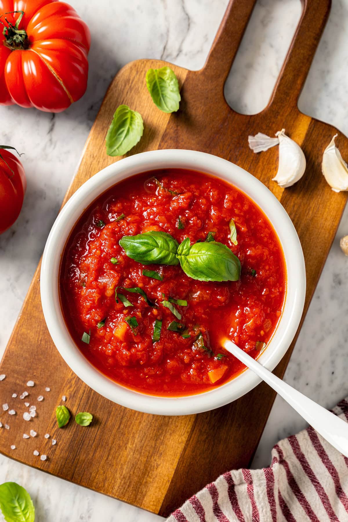 This filetto di pomodoro tastes far better than store-bought pasta sauces! You only need a few ingredients for this authentic Italian recipe. Bowl of filetto di pomodoro sauce with spoon.