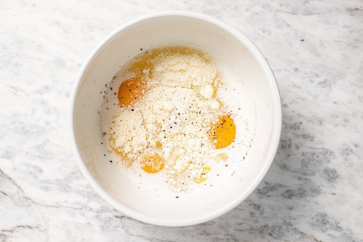 Eggs, egg whites, half-and-half, and seasonings combined in a bowl.