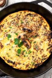 Overhead view of a mushroom frittata in a skillet.