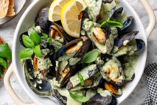 Bowl of mussels with basil cream sauce.