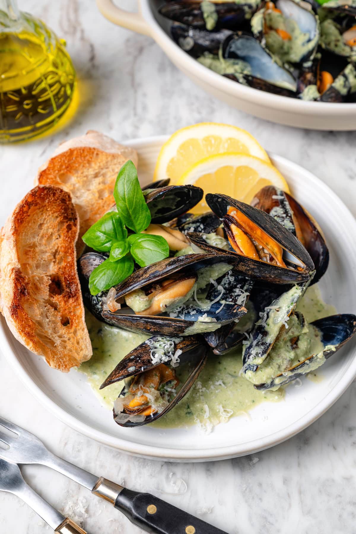 Plate of mussels with basil cream sauce and toast.