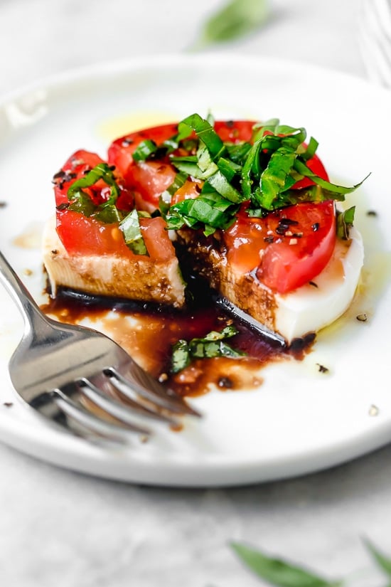 Caprese Salad or Insalata Caprese is a simple salad of fresh mozzarella and tomatoes topped with basil and a splash of balsamic. A perfect end of summer appetizer or side dish, especially when tomatoes are at their peak.