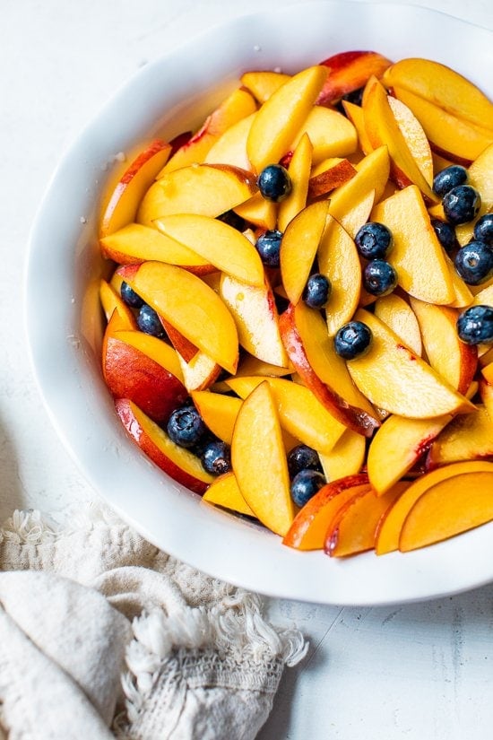 peaches and blueberries in a pie dish