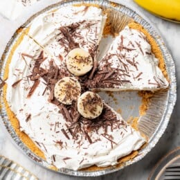 Overhead view of banana cream pie with one slice removed.