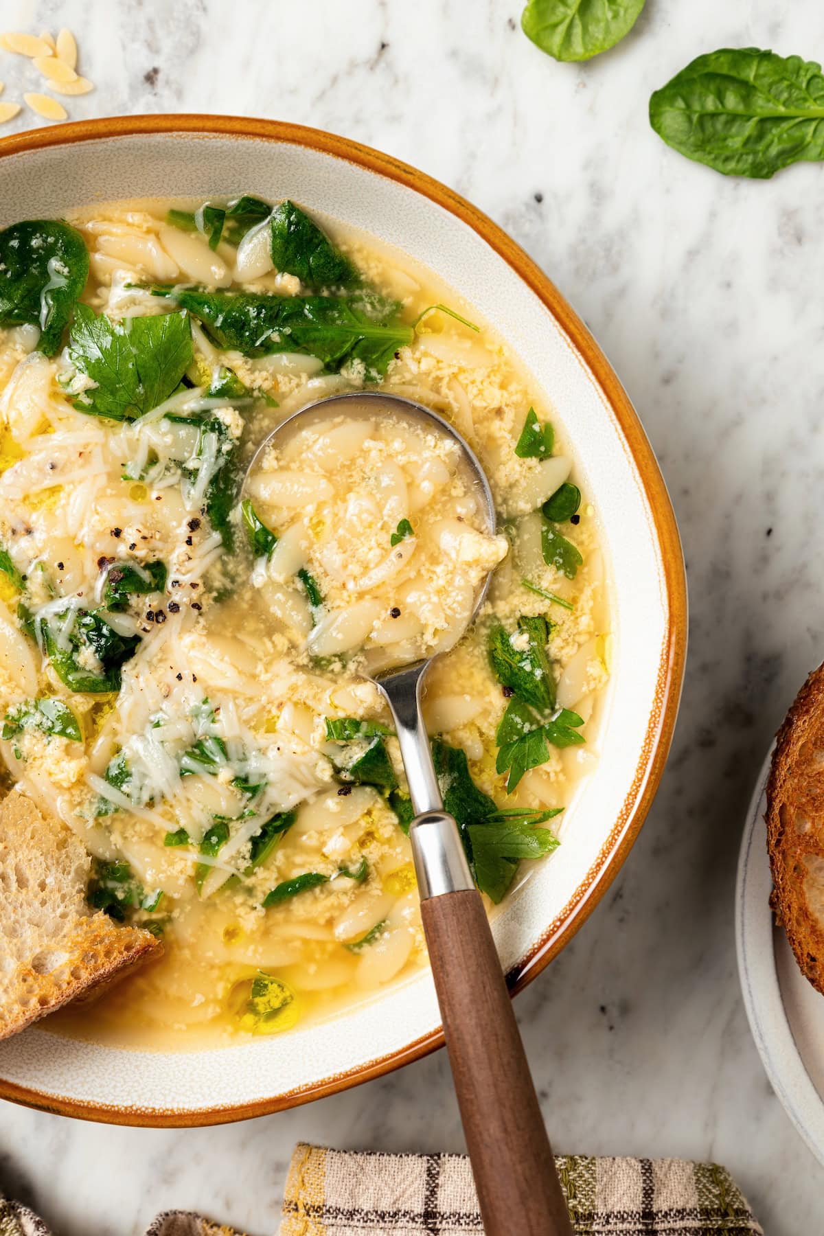 Spoonful of stracciatella soup in bowl.