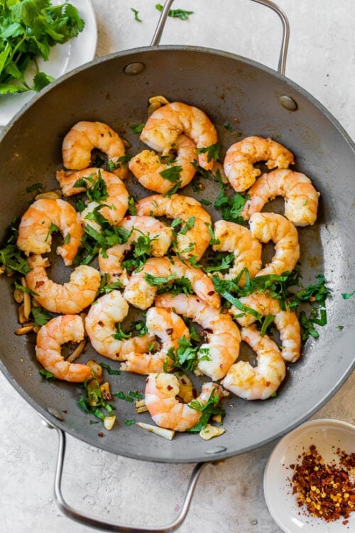 shrimp and parsley in skillet
