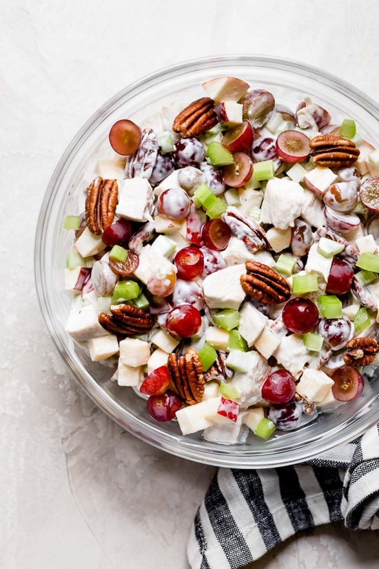 Creamy chicken Waldorf salad in glass mixing bowl.