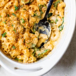 This creamy baked mac and cheese recipe is a lighter version of the classic recipe with added fiber from spinach. It's comfort food at it's finest!