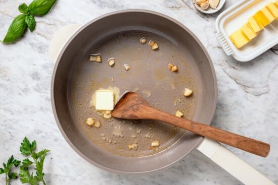 Butter melting in pan with wine and garlic.