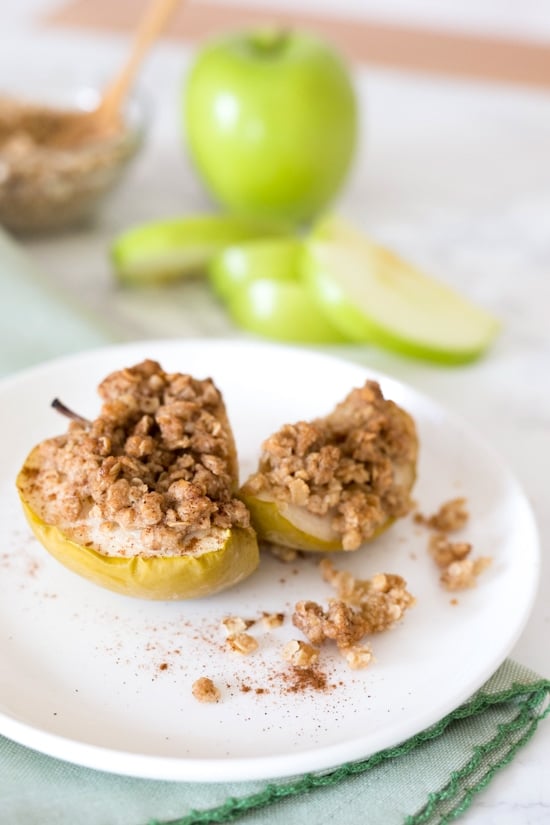 Baked apples topped with oats, cinnamon and a touch of brown sugar. Easy to make and a great way to use up those apples this Fall! They are like little individual apple crisps without all the added fuss of cutting and peeling the apples. A simple, light dessert for a cool autumn evening, serve this a la mode for an extra special treat!