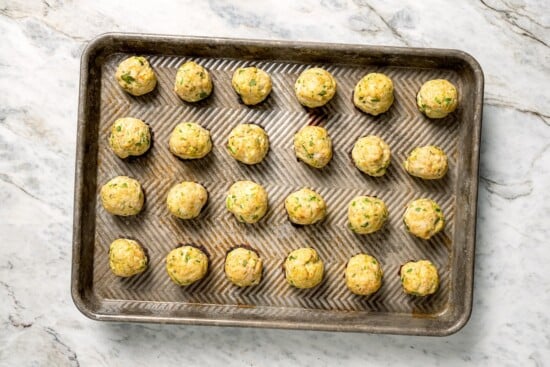 Rimmed baking sheet with baked southwest turkey meatballs.