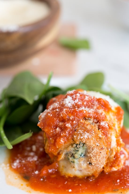 Chicken Rollatini with Spinach alla Parmigiana is Italian comfort food at it's finest! Made with breaded chicken breasts filled and rolled with spinach and cheese topped with sauce and melted mozzarella.
