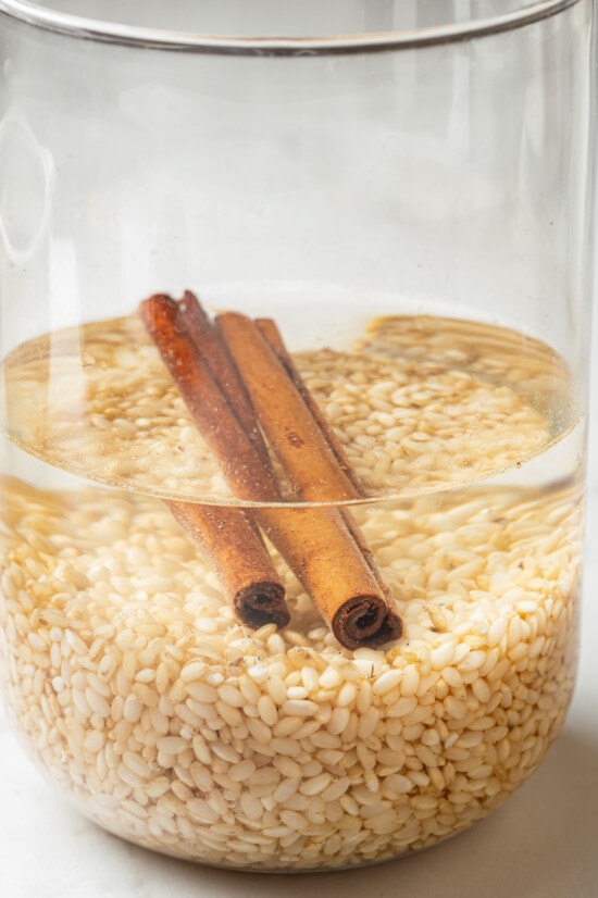 Brown rice and cinnamon sticks soaking in water