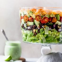 Mexican Shrimp Cobb Salad is a beautifully layered salad with shrimp, avocados, grilled corn, black bean salsa, cucumbers, tomatoes and cheese.