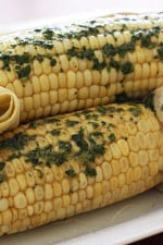 Sweet summer corn roasted in the oven and topped of with a light compound butter using fresh cilantro and a pinch of chipotle pepper and cumin.