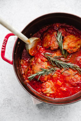Pollo in Potacchio is an Italian braised chicken dish made with tomatoes, rosemary and garlic. The chicken cooks until it's fork tender, which is great served with pasta, noodles, spaghetti squash or polenta.