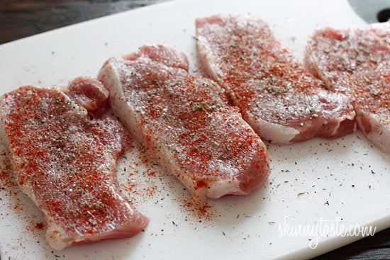 Raw pork loins seasoned with paprika, sage, thyme and spices on a plate.