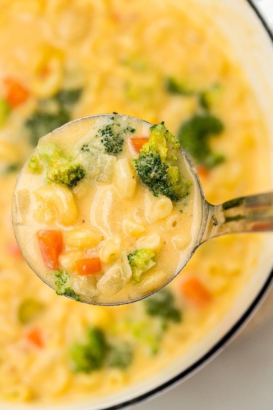 A big ladle with Macaroni and Cheese Soup with Broccoli