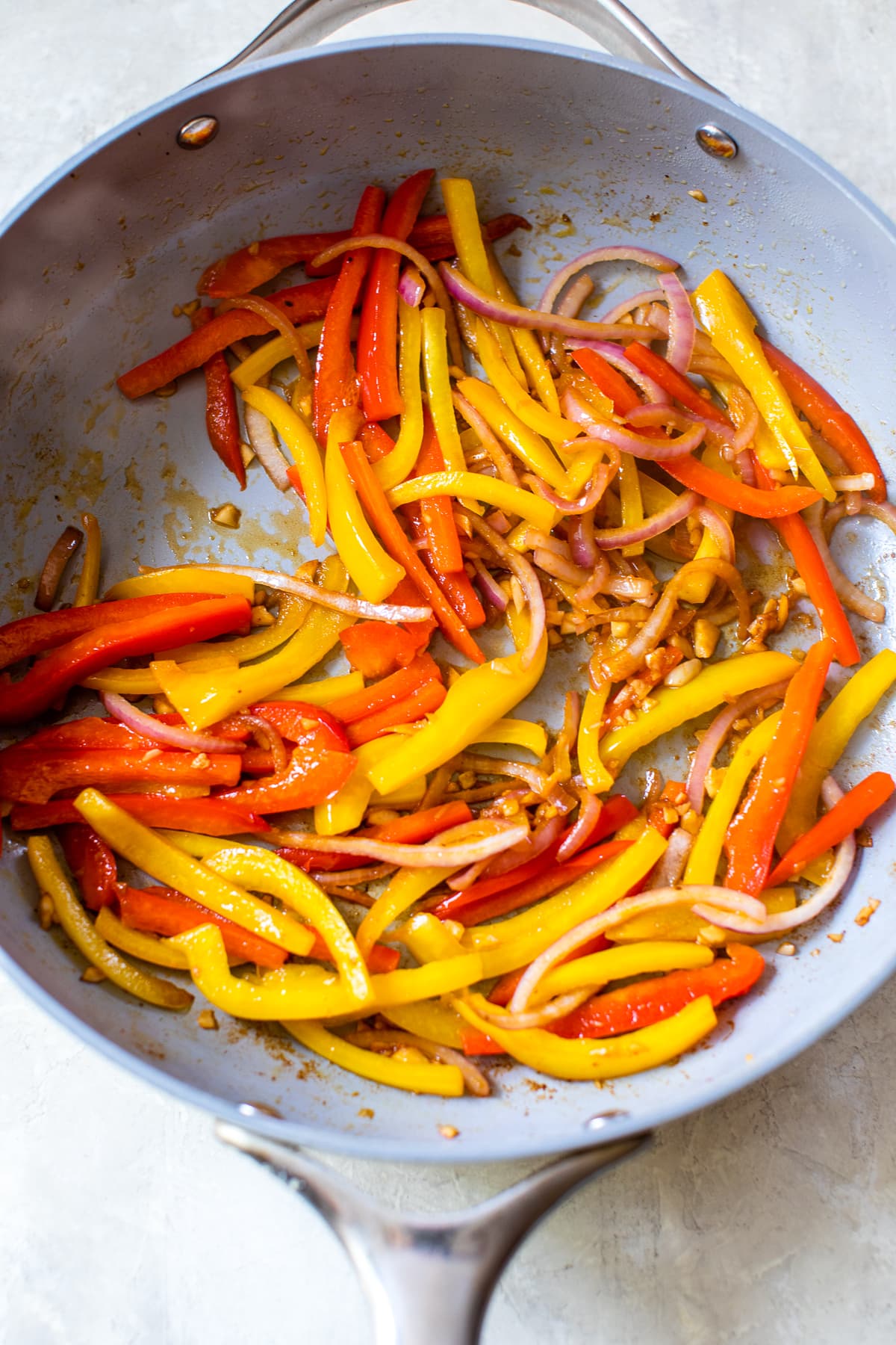 Sliced bell peppers in a skillet.