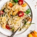 Angel hair pasta tossed with summer zucchini and tomatoes fresh from the garden. The perfect meatless meal you'll be craving again and again. Serve this with plenty of Parmigiano Reggiano!