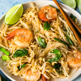 Pad Thai with shrimp on white plate with chopsticks
