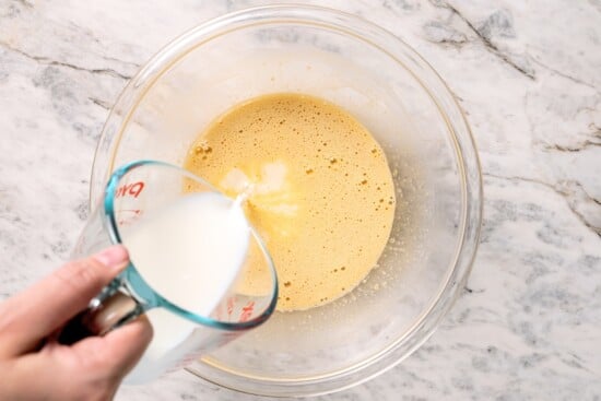 Pouring milk into clafoutis batter.