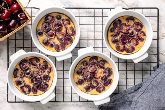 4 cherry clafoutis on wire cooling rack.