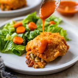 drizzling hot sauce over stuffed chicken breast