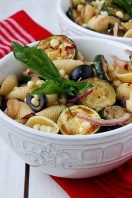 This warm pasta salad is big on summer vegetables, corn and zucchini, with a small kick of red pepper. A great sub to potato salad and a perfect meatless entree or side dish for your next picnic or family potluck.