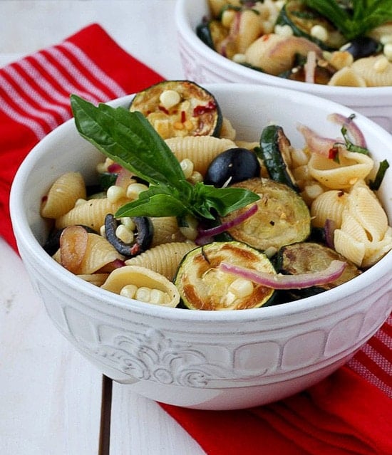 This warm pasta salad is big on summer vegetables, corn and zucchini, with a small kick of red pepper. A great sub to potato salad and a perfect meatless entree or side dish for your next picnic or family potluck.