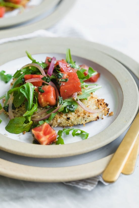 Baked Chicken Milanese is made with breaded chicken cutlets, baked in the oven topped with arugula, tomatoes and balsamic. This is my favorite restaurant dish, made healthier!