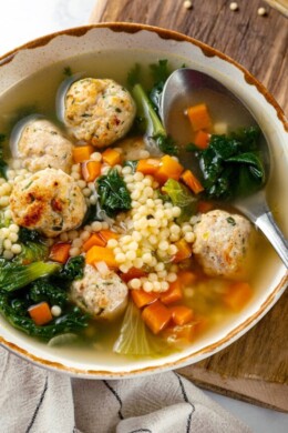 A bowl of Italian wedding soup with a spoon