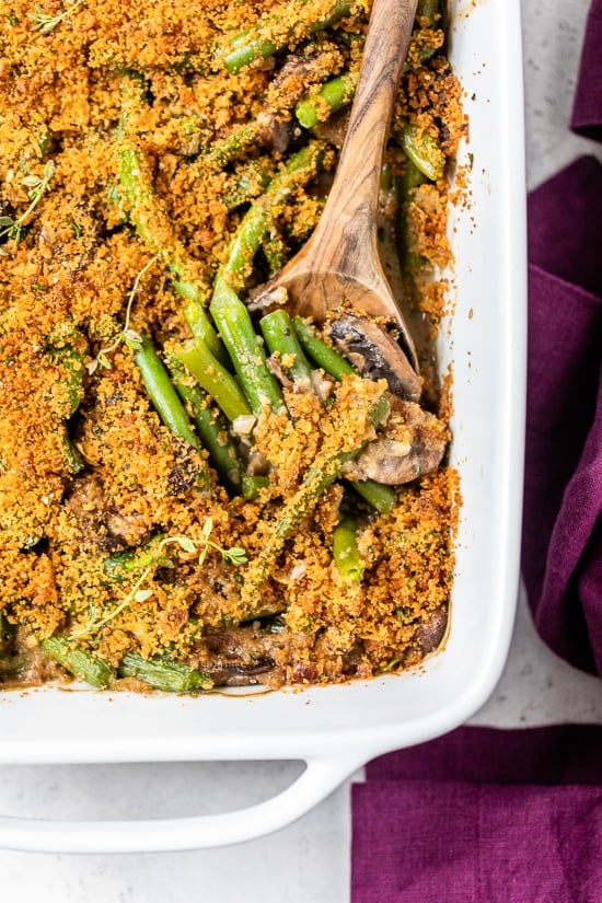Green Bean Casserole in a casserole dish with a wooden spoon