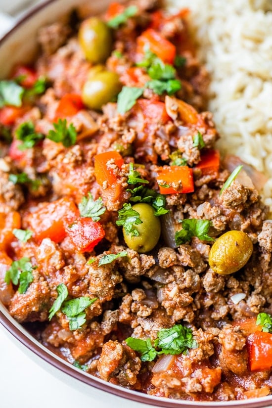 Crock Pot Picadillo is a flavorful Cuban dish made with ground beef and a sauce made from simmering tomatoes, green olives, bell peppers, cumin, and spices.