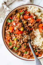 Crock Pot Picadillo is a flavorful Cuban dish made with ground beef and a sauce made from simmering tomatoes, green olives, bell peppers, cumin, and spices.