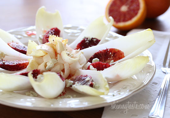 A plate with endive pieces with a blood orange segment in each, topped with Gorgonzola cheese