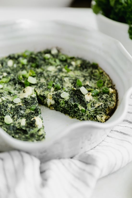 A simple Greek inspired Easy Crust-less Spinach and Feta Pie combining savory flavors such as spinach, feta, Asiago cheese, dill and scallions. Perfect to take to a potluck!
