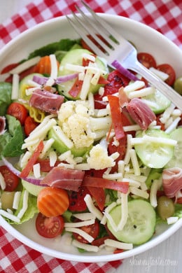 Chopped romaine hearts, shredded mozzarella, olives, prosciutto, turkey pepperoni, roasted red peppers, cucumbers, tomatoes, pepperoncini and Giardiniera (colorful vegetables in vinegar) – this quick Italian antipasto salad requires no cooking, which makes it perfect to whip up or pack for lunch.