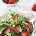 Strawberry salad made with mixed greens, kale and spinach, sliced almonds, crumbled gorgonzola cheese and topped with poppy seed dressing – perfect for summer!
