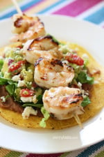 Grilled Shrimp Tostadas are SO good, layered with homemade guacamole, refried beans and lettuce on top of a crispy tostada.