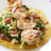 Grilled Shrimp Tostadas are SO good, layered with homemade guacamole, refried beans and lettuce on top of a crispy tostada.