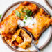 Easy vegetarian enchiladas made with butternut squash and black beans, smothered with enchilada sauce and cheese, then baked in the oven. A delicious recipe that's perfect for meatless Mondays!