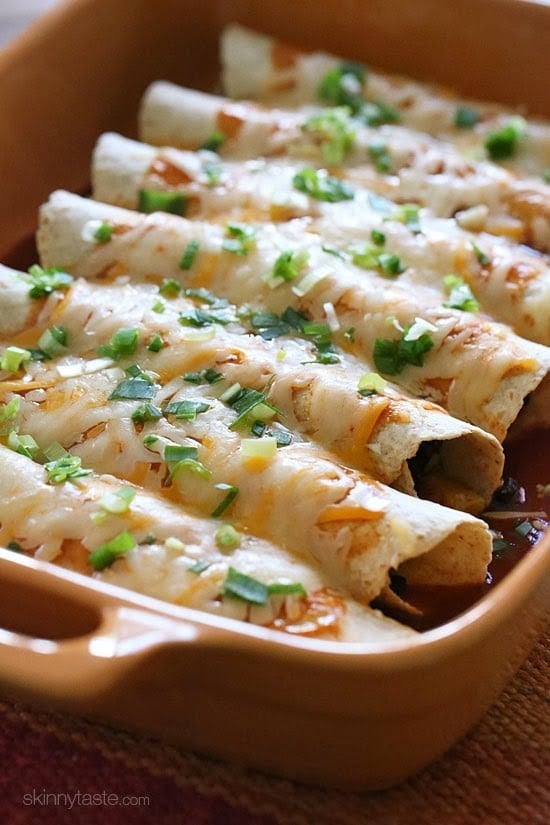 Butternut squash, black beans, tomatoes, cilantro and spices are simmered in a skillet with green chilies and jalapeno, then wrapped in tortillas and baked in the oven with enchilada sauce and cheese – these vegetarian enchiladas are delicious and perfect for meatless Mondays, or any day of the week! 