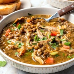 Bowl of chicken lentil soup with spoon.