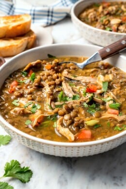 Bowl of chicken lentil soup with spoon.