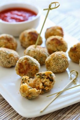 These mini baked Italian rice balls are made with brown rice, chicken sausage, spinach and mozzarella cheese. Served with some warm marinara sauce, they make the perfect finger foods for the Holiday season or any time you want to serve appetizers.