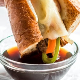 Slow Cooker French Dip Sandwich with Caramelized Onions filled with beef, melted cheese and au jus (beef broth) for dipping.